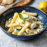 Una ciotola di pasta con verdure e formaggio.